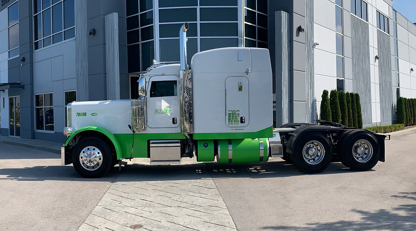 Side view of Seven Horses truck cab driving in front of Surrey, British Columbia head terminal