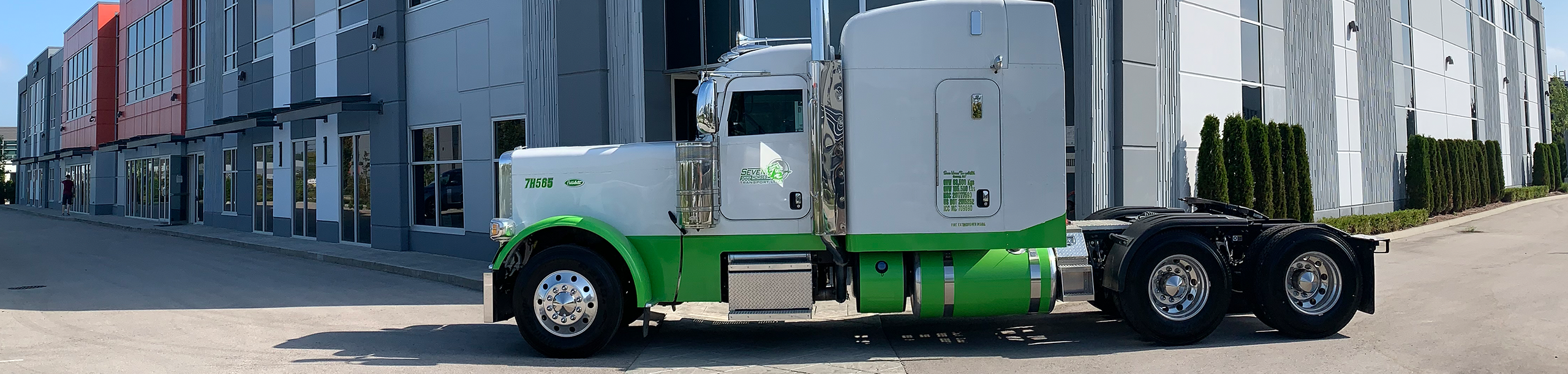 Side view of Seven Horses truck cab driving in front of Surrey, British Columbia head terminal
