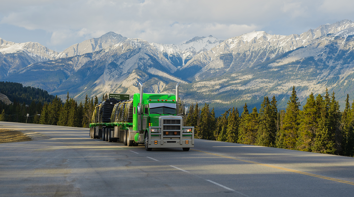 Seven Horses highway truck transporting heavy haul goods in front of West Coast forest and mountains