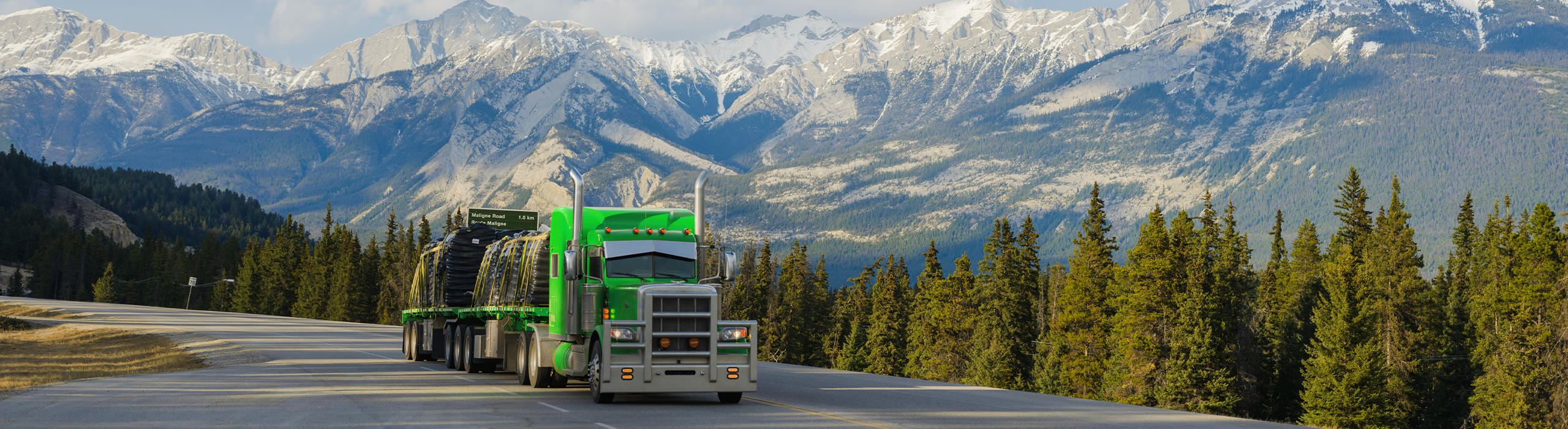 Seven Horses highway truck transporting heavy haul goods in front of West Coast forest and mountains