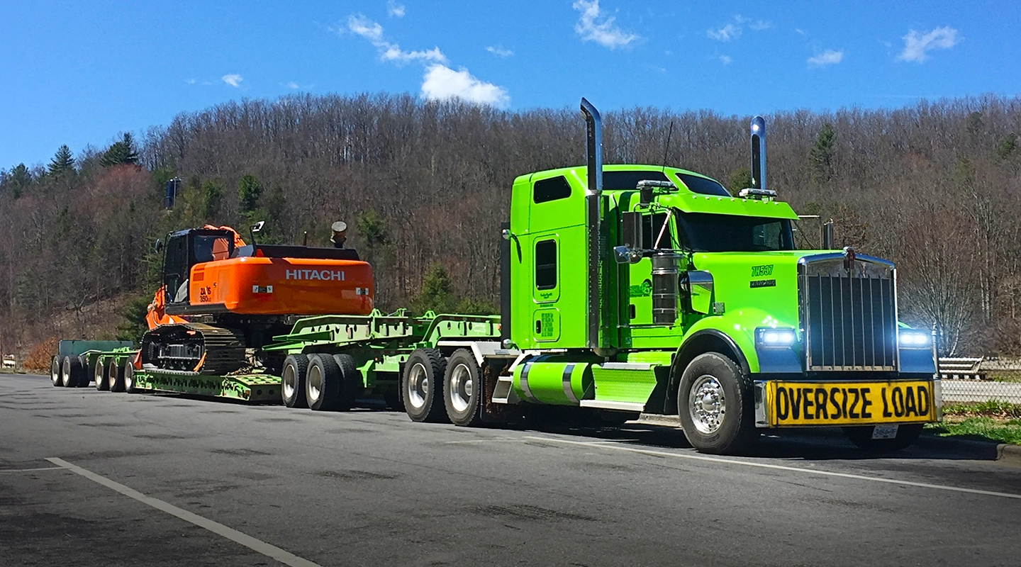Seven Horses truck hauling oversized construction machinery on West Coast highway